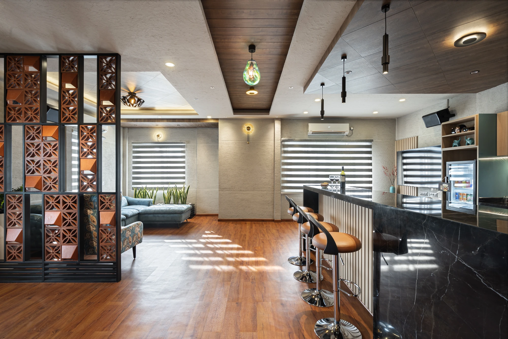 Lounge with bar counter and jaali partition by Space Decor